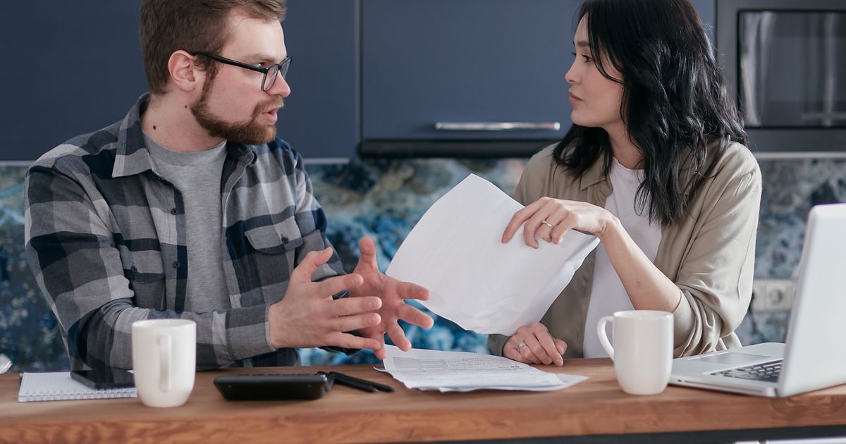 Man en vrouw in gesprek aan tafel met documenten