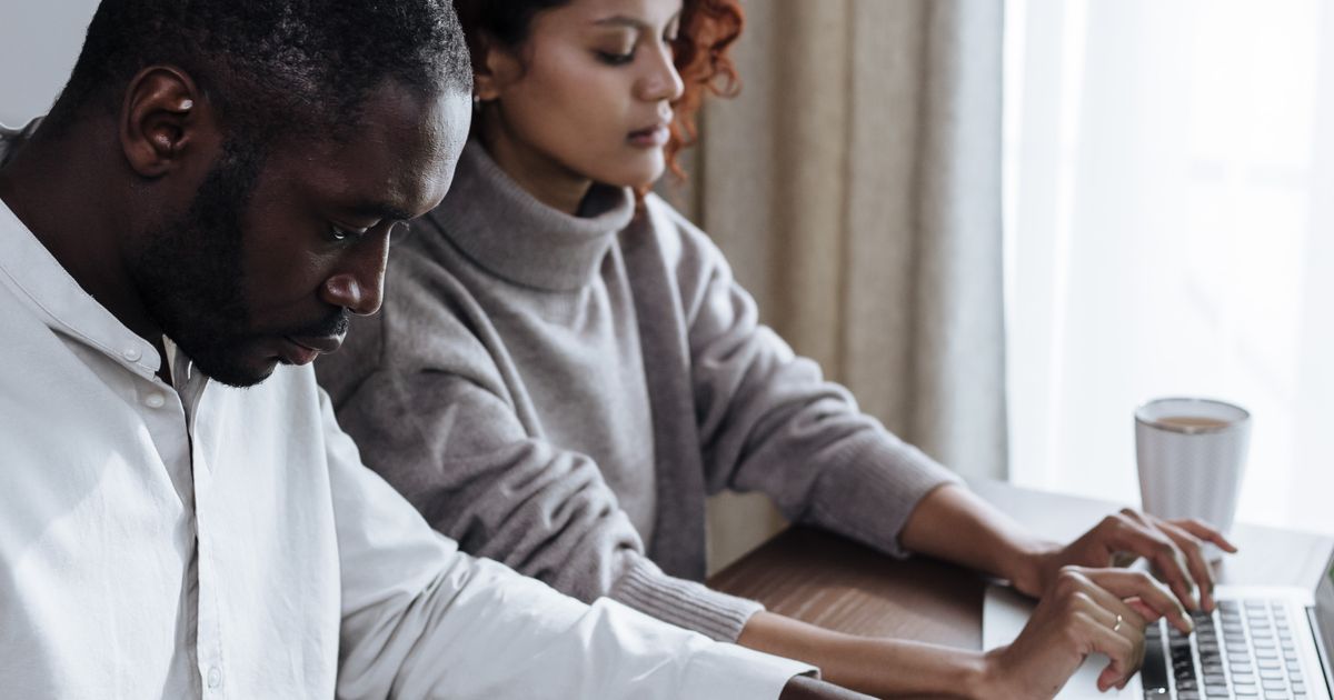 Twee mensen bekijken samen rustig documenten en financiële zaken aan tafel