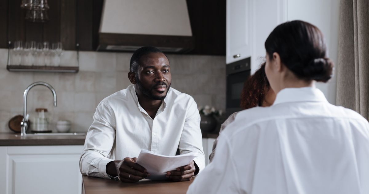 Man en vrouw bespreken samen documenten aan de keukentafel