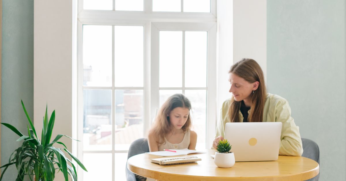Moeder en dochter maken samen huiswerk aan tafel, sfeerbeeld bij het ouderschapsplan