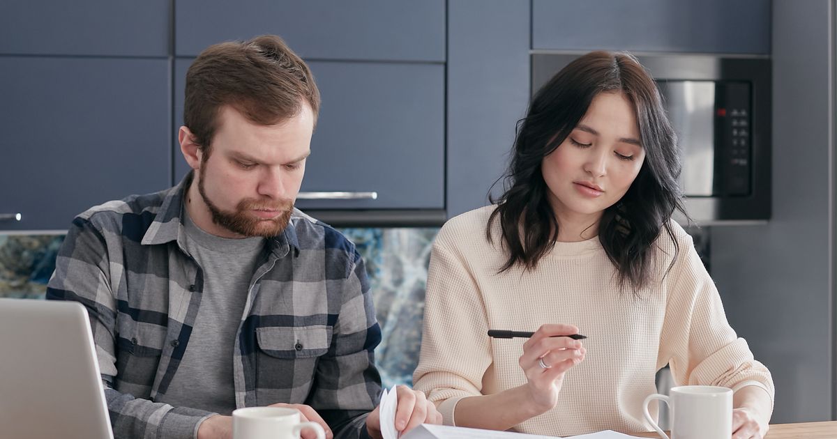 Man en vrouw overleggen samen rustig aan tafel met een laptop