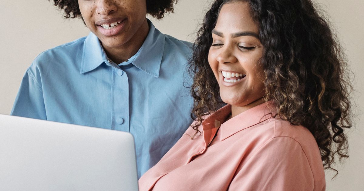 Man en vrouw kijken samen glimlachend naar een laptopscherm