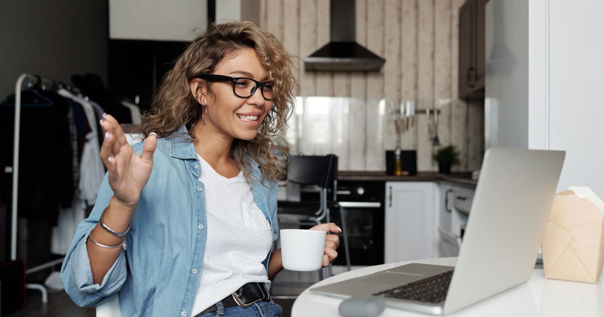 Vrouw voert een videogesprek op haar laptop vanuit huis