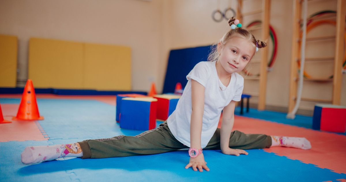 Meisje oefent een gymnastiekoefening tijdens een sportles