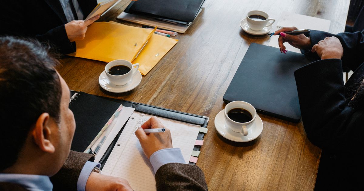 Diverse groep mensen overlegt rustig aan tafel tijdens een gesprek over de online echtscheiding