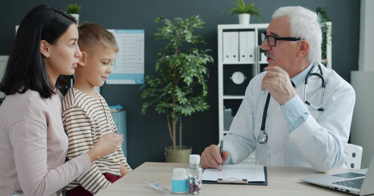 Moeder en zoon in gesprek met een arts over medische zorg voor hun kind