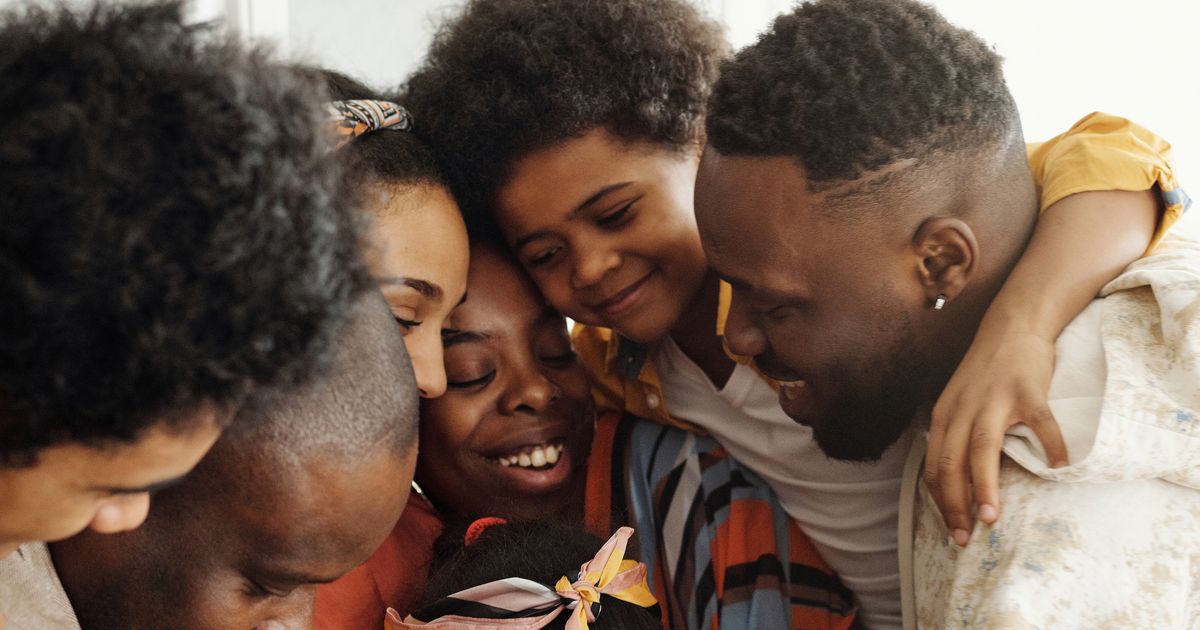 Ouders en kinderen van een samengesteld gezin omhelzen elkaar liefdevol